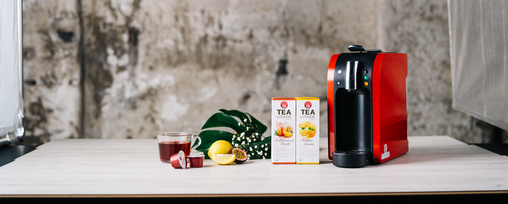 rote Tealounge System Maschine neben Teekapseln