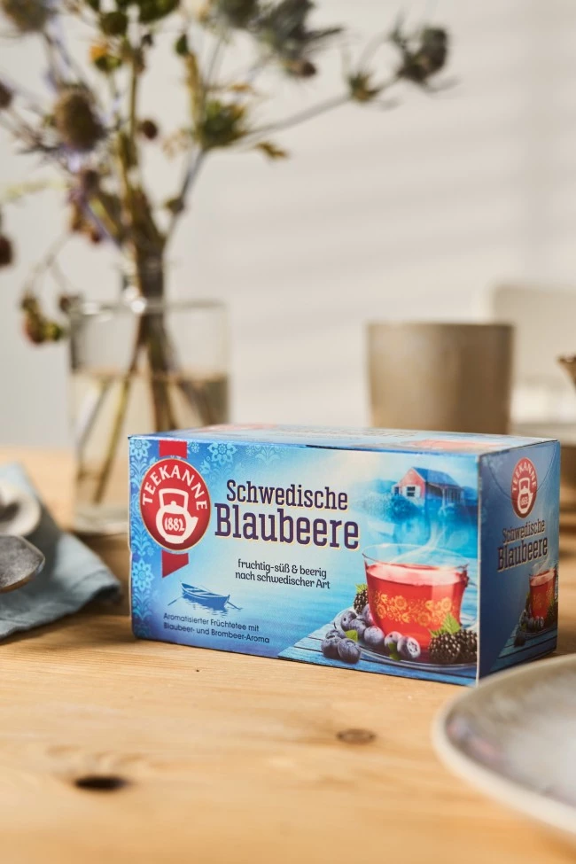 Teekanne Schwedische Blaubeere Teedose mit Blaubeeren, nordische Hütte, auf Tisch mit Besteck.