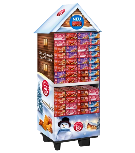 Hausförmiges Winterdisplay mit Lebkuchenschachteln, Schneedekor, Schneemannbild und Text So schmeckt der Winter.