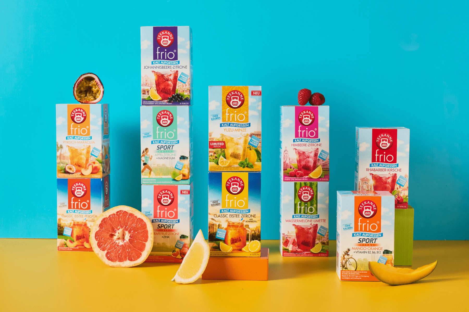 Blauer Hintergrund, gelber Untergrund. Dazu 11 Sorten von TEEKANNE frio, dem Tee zum kalt Aufgießen. Dekoriert mit verschiedenen Früchten.