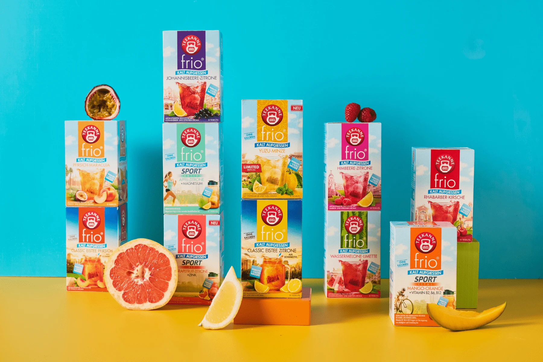 Blauer Hintergrund, gelber Untergrund. Dazu 11 Sorten von TEEKANNE frio, dem Tee zum kalt Aufgießen. Dekoriert mit verschiedenen Früchten.